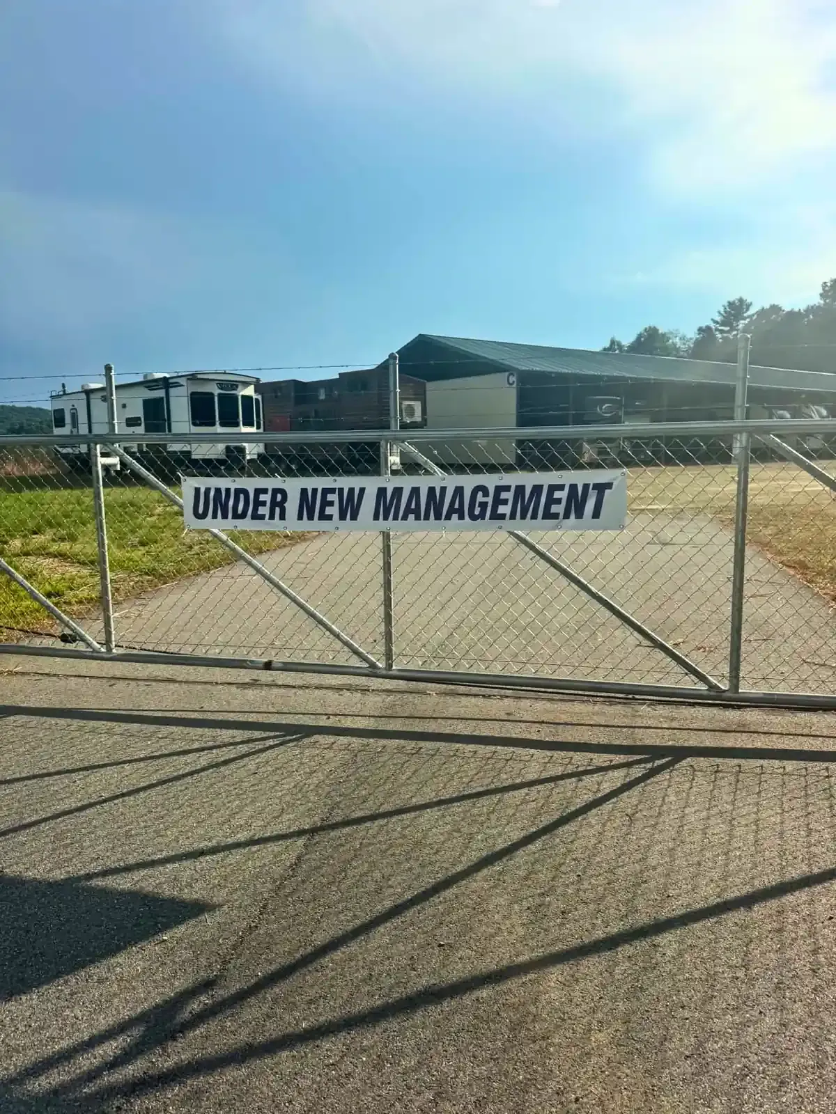 Entrance gate with an "under new management" banner